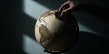 Catalyzing Tomorrow: Advanced Business Insights for Exponential Growth An aged globe with an antique brass compass, dramatically lit, symbolizing strategic navigation through global economic shifts.